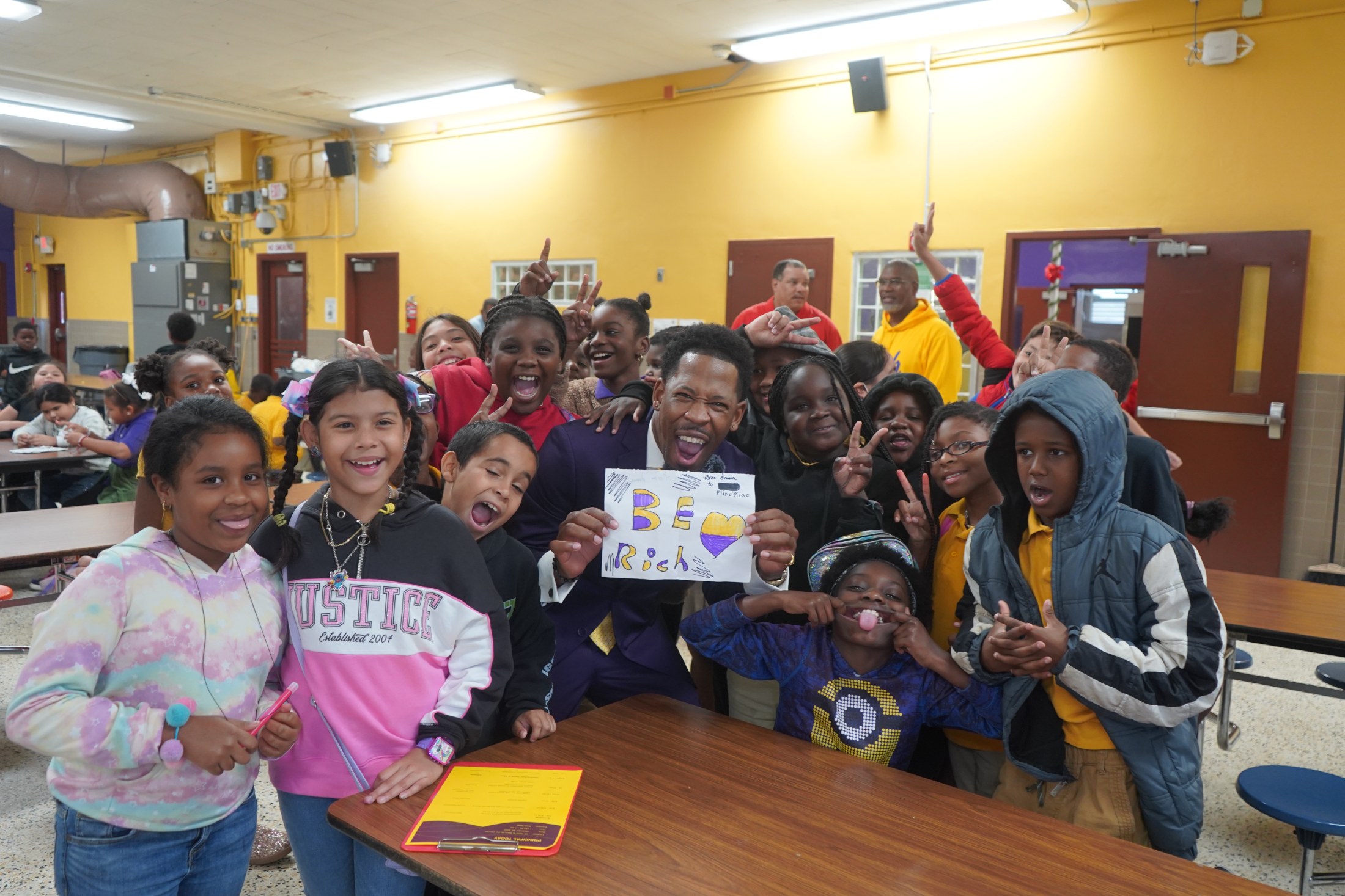 Brian E. Sibley with students holding a hand-drawn BE Rich sign