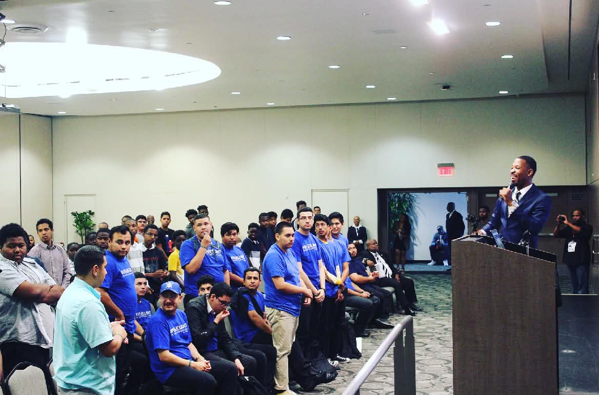 Brian E. Sibley speaking from a podium to a room of young men at Cal State Dominguez Hills