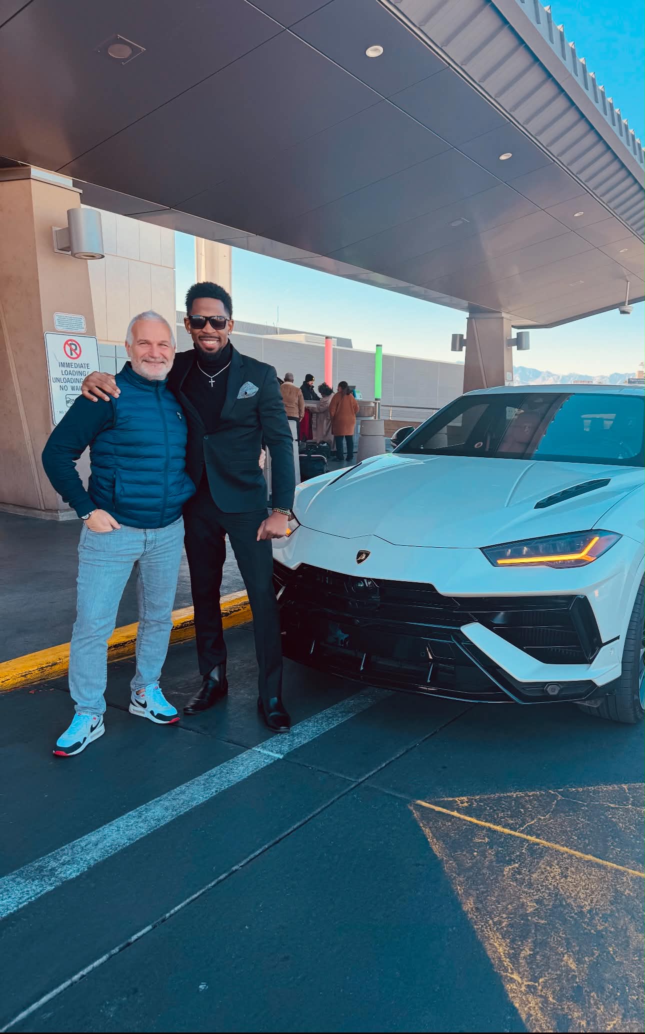 Brian E. Sibley standing with the Marketing Director of Lamborghini in front of a Lamborghini Urus