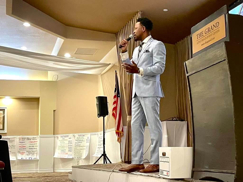 Brian E. Sibley speaking on stage at the Long Beach Rotary Club