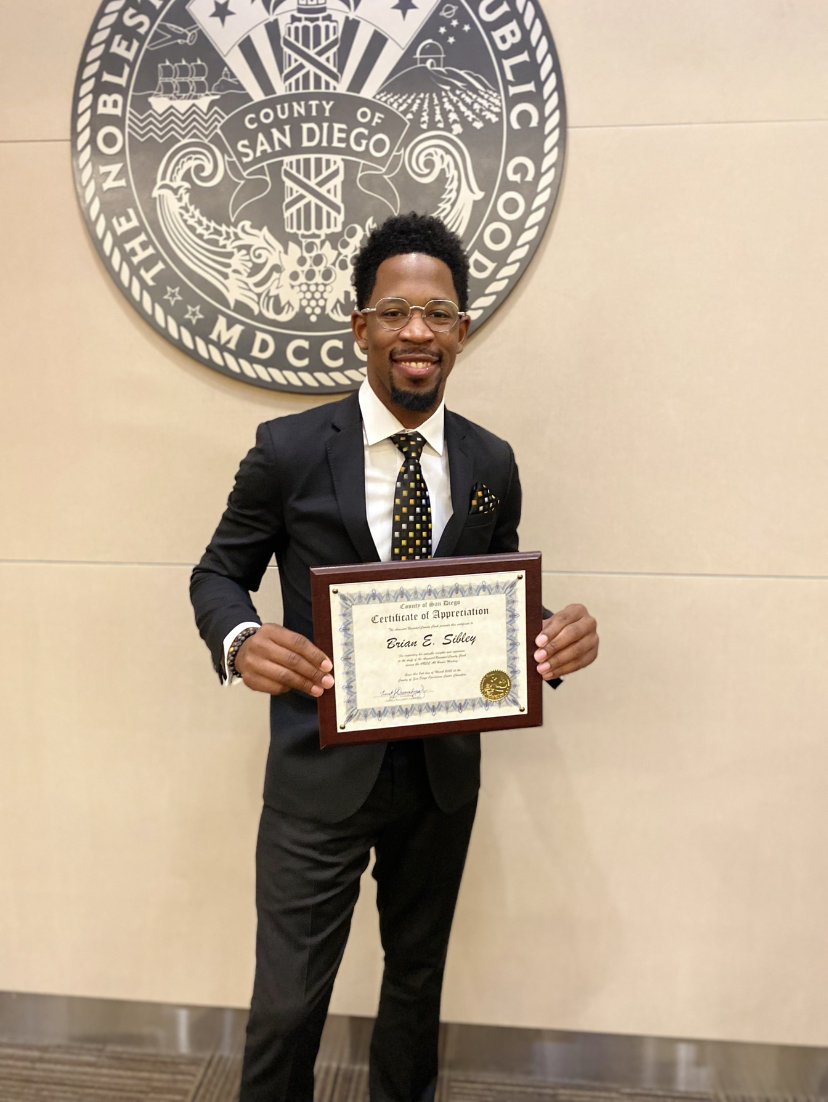 Brian E. Sibley with a certificate from San Diego County