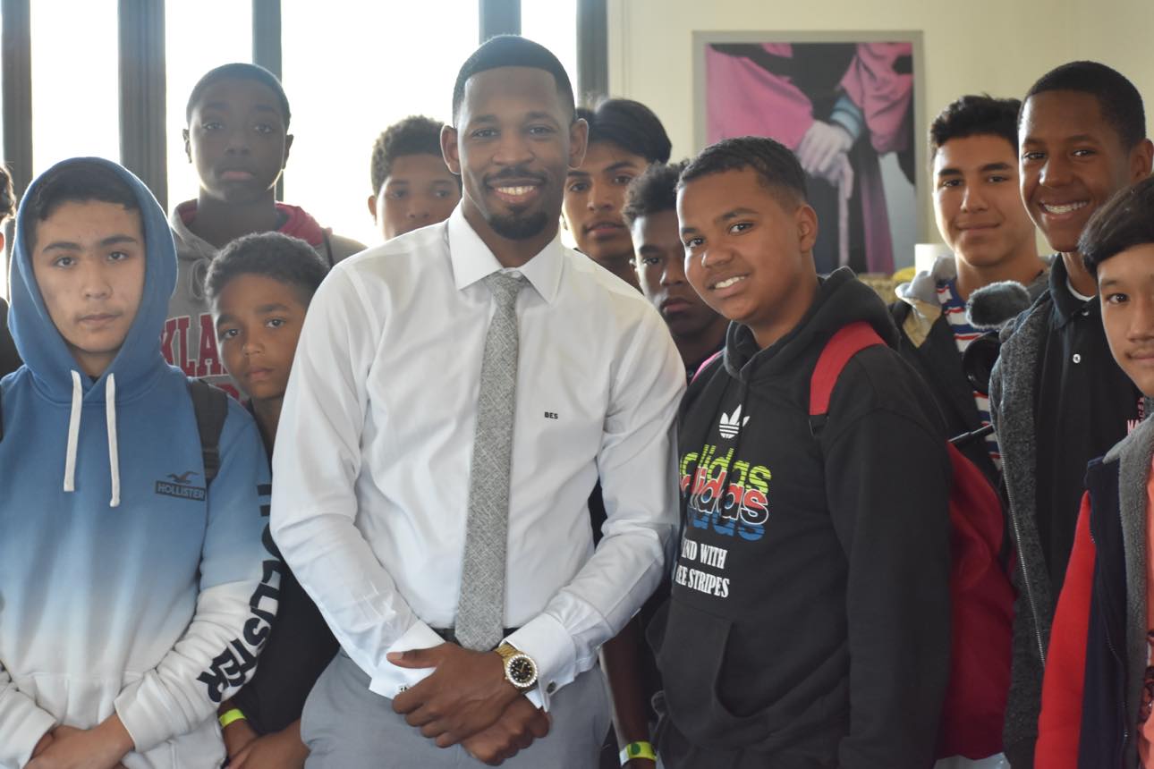 Brian E. Sibley smiling with a group of middle school young men